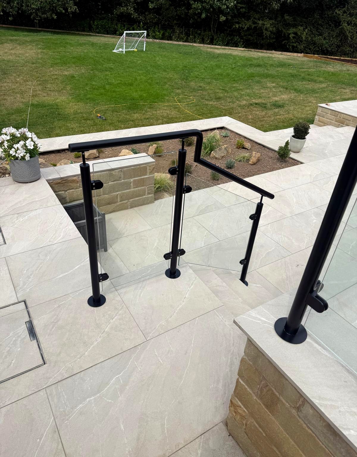 Black powder-coated steel balustrade posts with glass infill and cover roses, Sheffield